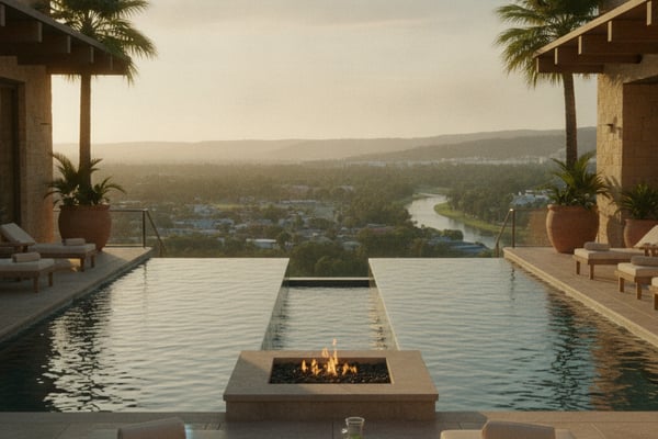 Luxury infinity pool with fireplace overlooking river valley and forested landscape at sunset